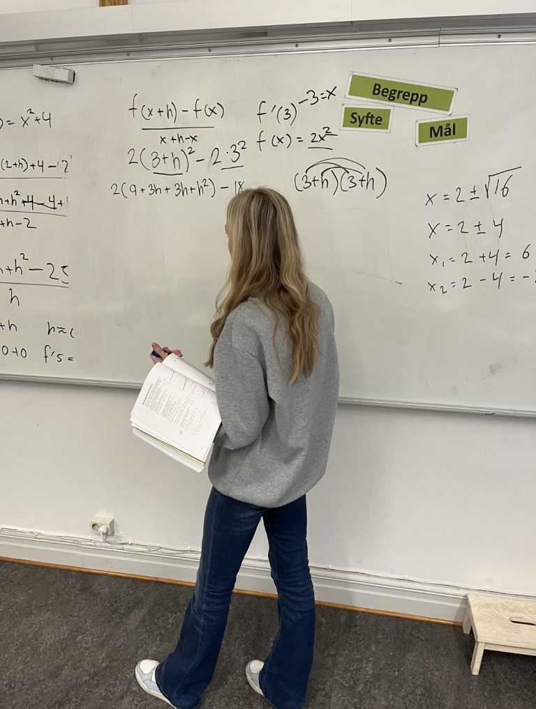 Elev står framför vita tavlan och visar deriveringen med derivatans definition.