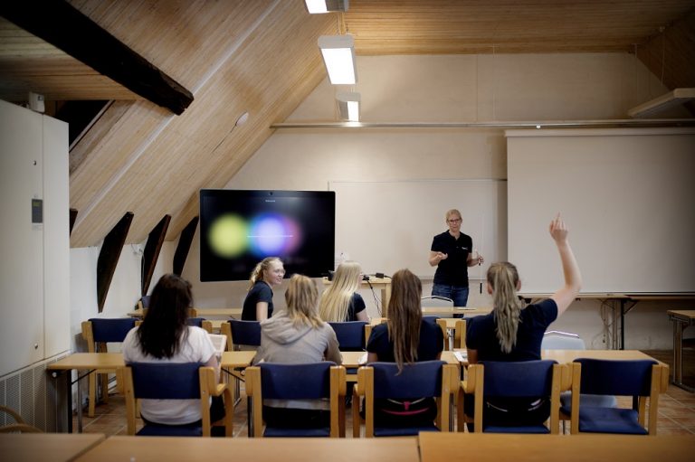 Interiör från klassrum med lärare och elever.