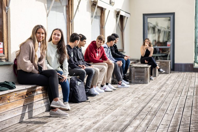 Eleverna sitter ute på balkongen i solen i väntan på nästa lektion. 