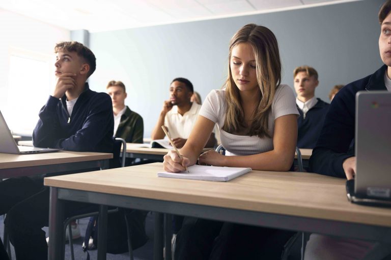 Elever i ett klassrum som fokuserar på sina studier.