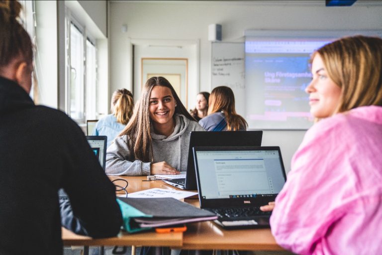 Elever sitter i klassrummet och har ett grupparbete.