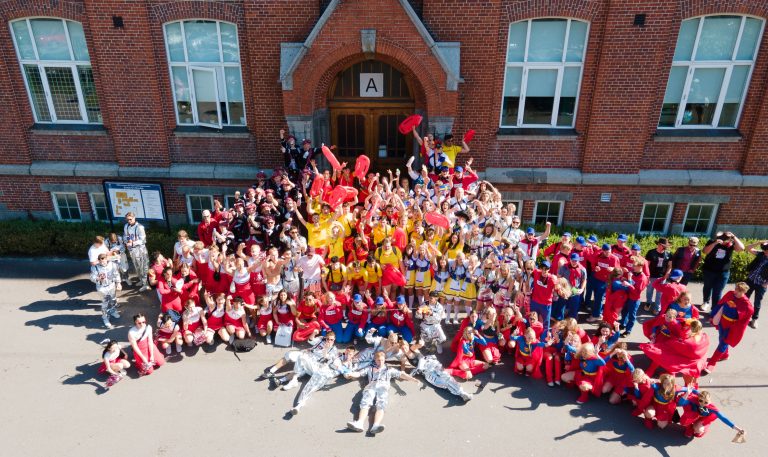 Utklädda elever i avgångsklasserna står framför skolingången i uppstarten av studentveckan.