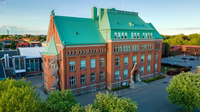 Skolbyggnaden S:t Nicolai med solsken och blå himmel som bakgrund