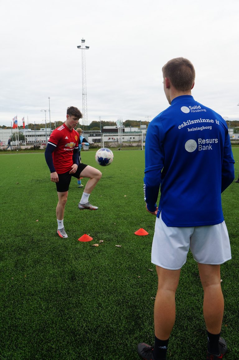 Två elever tränar fotboll.