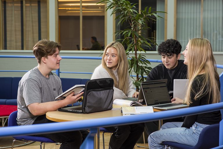 Elever i grupparbete i trevlig studiemiljö.