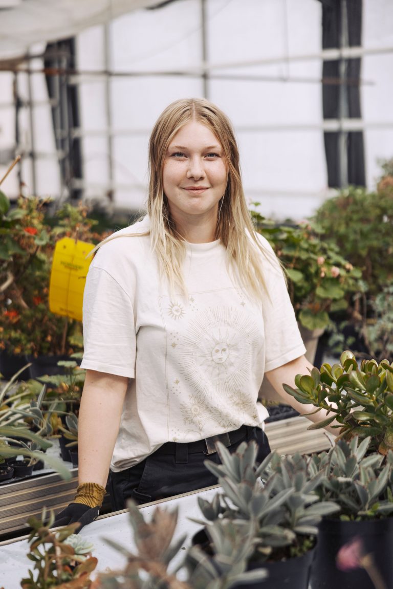 Elev arbetar i växthuset med vattning och skötsel av växterna.