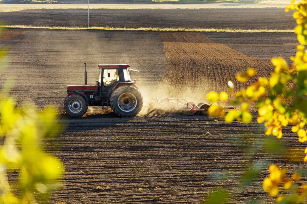 Traktor som harvar på en åker.