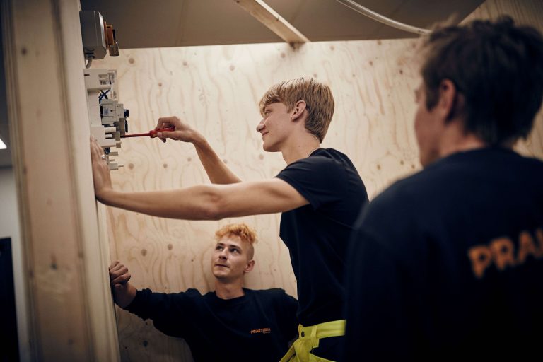 Tre fokuserade elever på el- och energiprogrammet arbetar med installation i skolans el-verkstad.