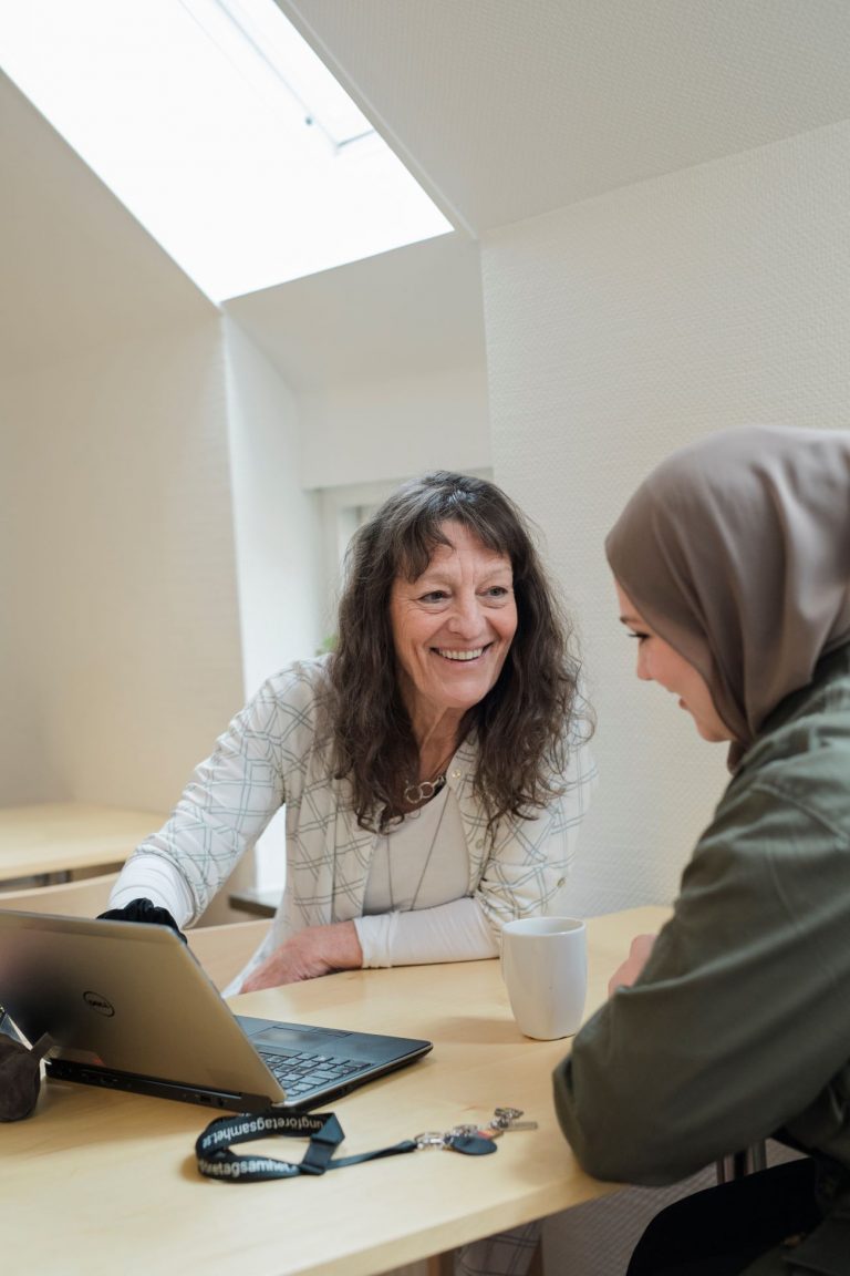 Elev och specialpedagog sitter vid ett bord med en laptop i vår studieverkstad.