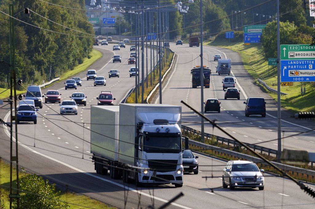 Lastbil och bilar som kör på motorväg.