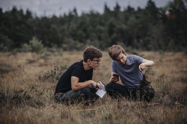 Två elever gör en undersökning i naturen.