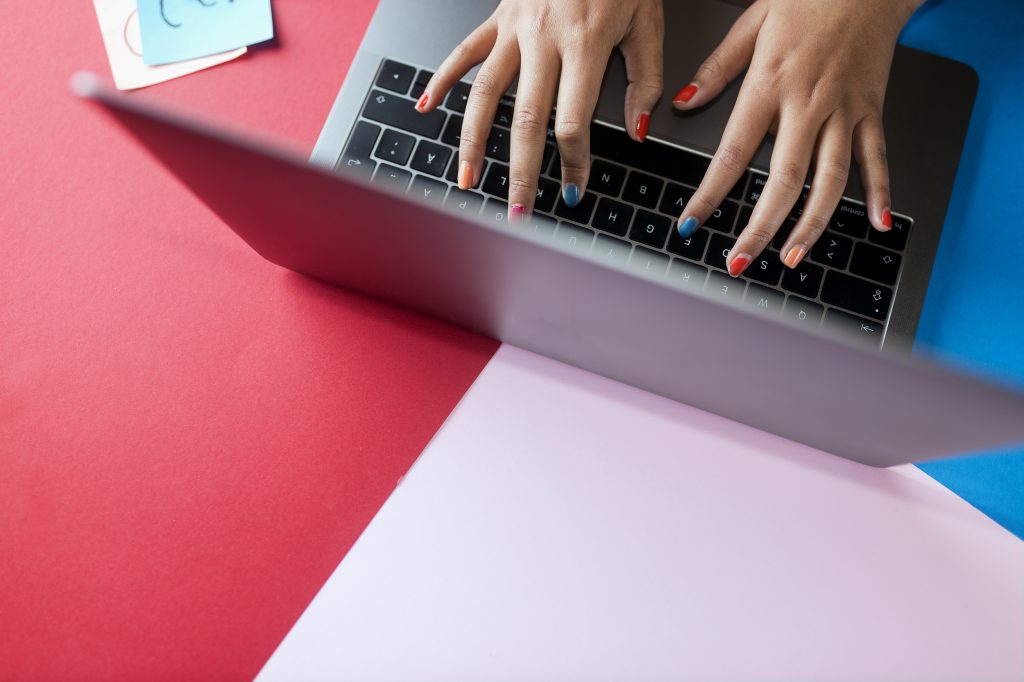 Laptop uppifrån med händer på tangentbordet.