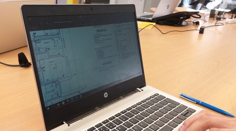 En hand vid en datorskärm. På skärmen visas ett kopplingsschema för el.