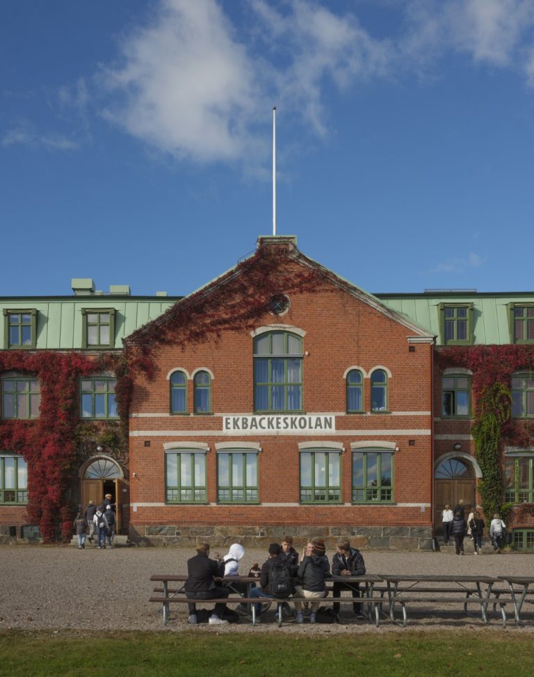 Gamla skolan med elever framför.