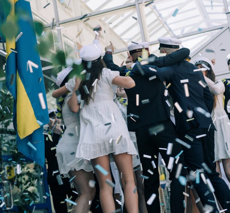 Elever som tar studenten samt konfetti och en svenska flagga.