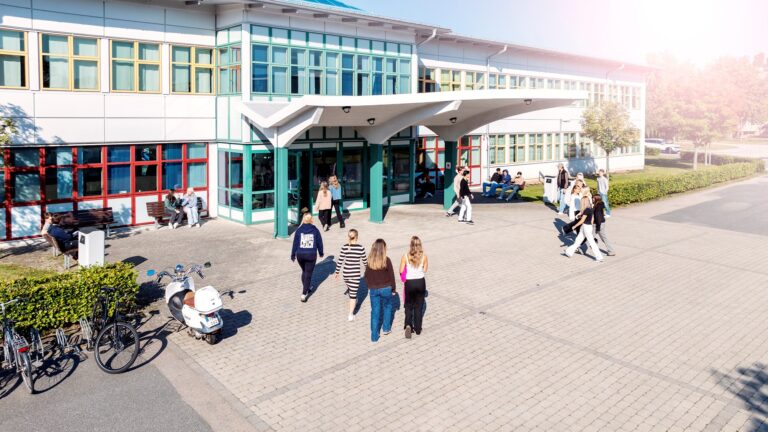 Elever vid huvudentrén på väg in i skolan.