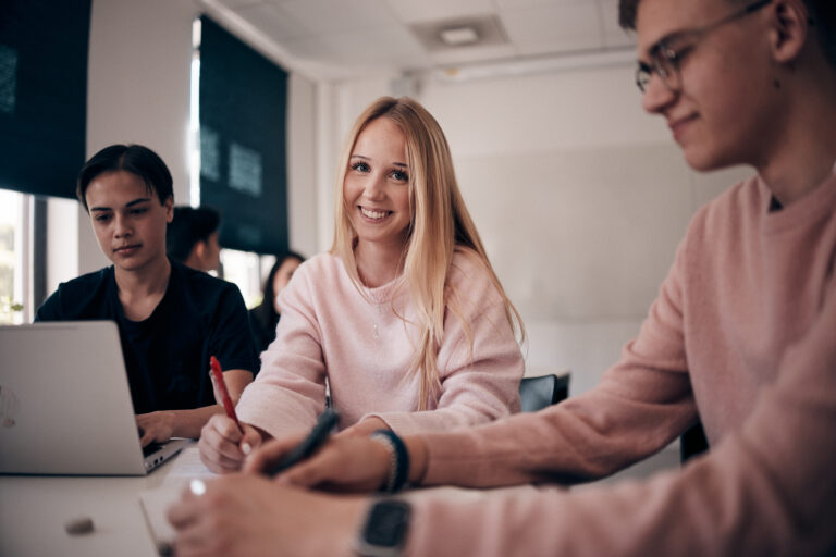 Elev som arbetar i klassrummet och ler mot kameran. 