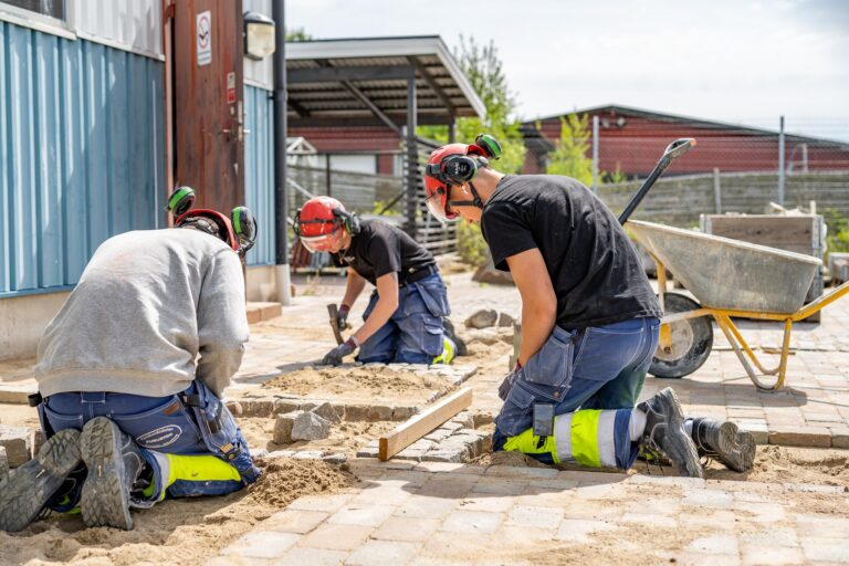 Tre yrkeselever gör en stenläggning