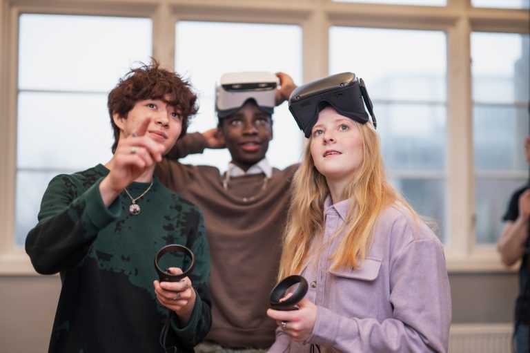 Tre engagerade elever som jobbar med VR.